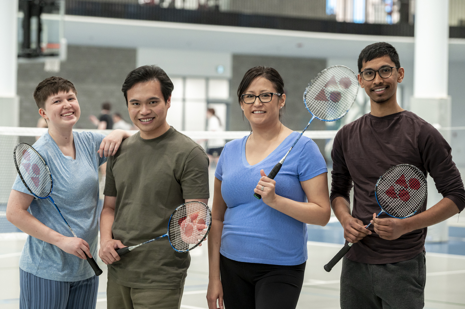 Four people holding sports racquets
